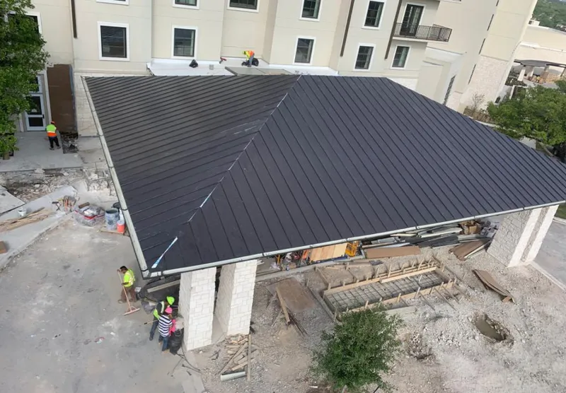 Metal roofing installation team working on a commercial building in Shirley